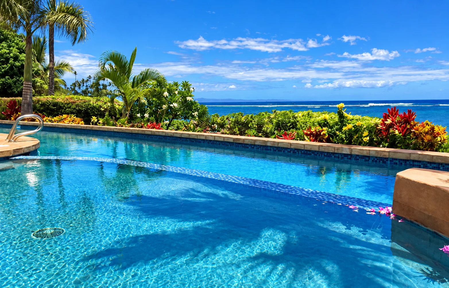 An oceanfront swimming pool framed by tropical gardens in Maui